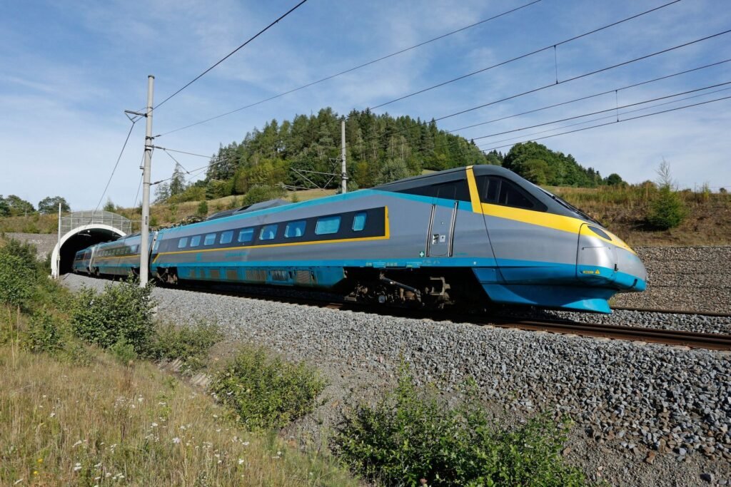 Jednotka Pendolino Českých drah projíždějící po elektrizované železniční trati u tunelu