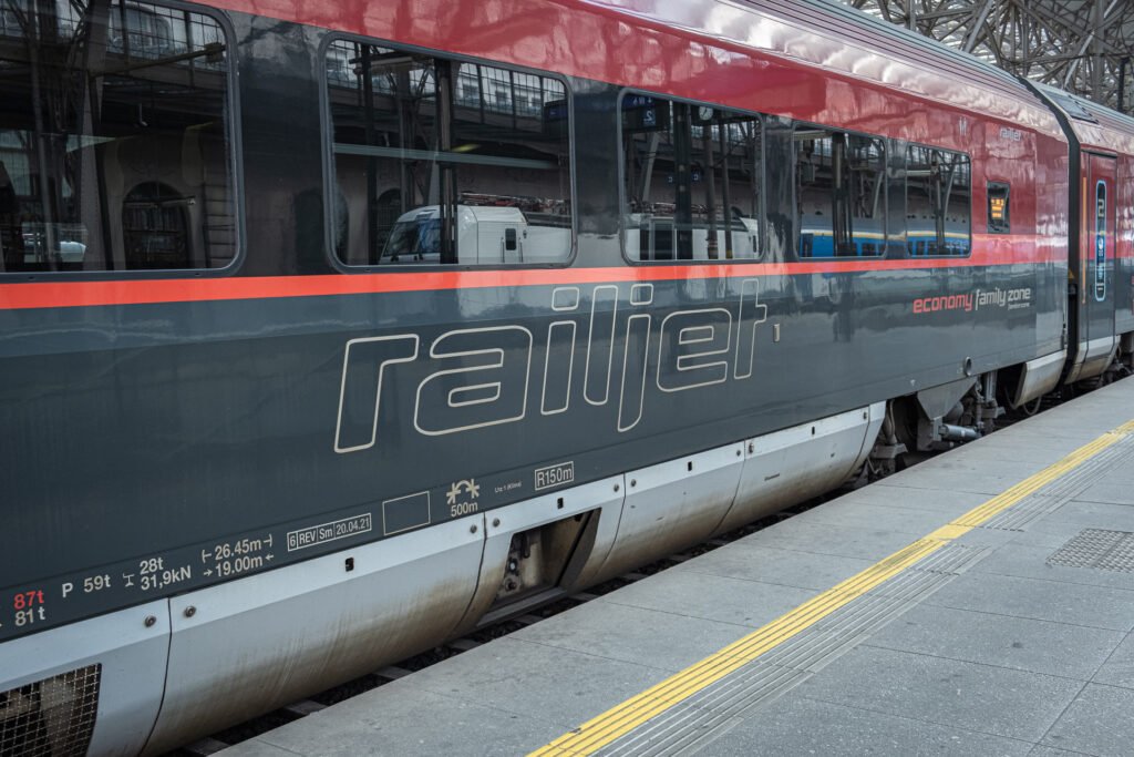Vůz soupravy Railjet rakouského dopravce ÖBB stojící u nástupiště na železniční stanici