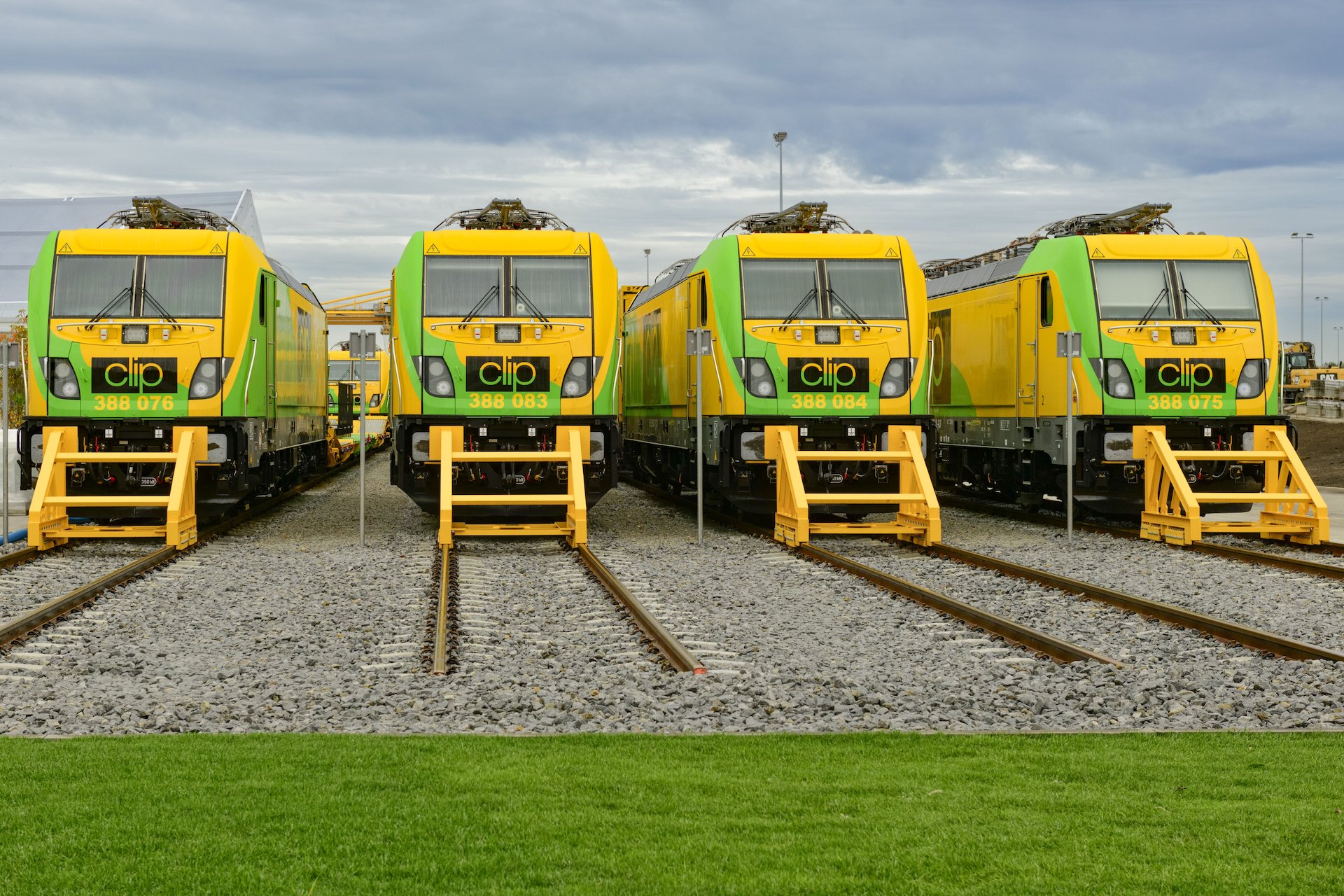 Čtyři zelenožluté elektrické lokomotivy Alstom Traxx Universal polského dopravce CLIP Intermodal stojící vedle sebe na kolejích