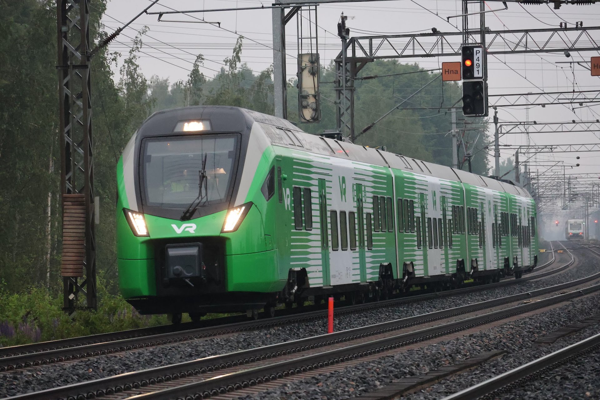Zelenobílá elektrická jednotka Stadler FLIRT řady Sm7 během zkušební jízdy na elektrifikované železniční trati ve Finsku